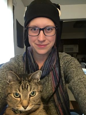 Dr. Becky Stuntebeck, board-certified shelter medicine veterinarian, smiling with her tabby cat, contributing expertise in facility design and population management as a project collaborator at JVR Strategies