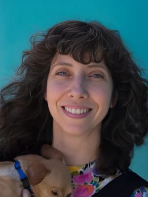 Dr. Elizabeth Roberts, board-certified shelter medicine veterinarian, holding a puppy and contributing deep expertise in public health, epidemiology, and animal shelter systems as a consultant at JVR Strategies